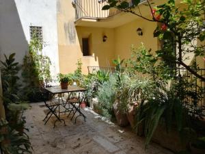 a courtyard with a table and some plants at Residenza Bagolino in Alcamo