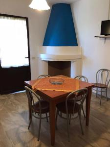 une table à manger avec des chaises et un plafond bleu dans l'établissement Appartamenti Alessio, à Girasole