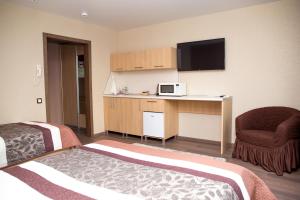 a hotel room with two beds and a television at Roomer in Chelyabinsk