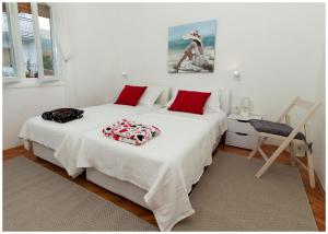 een slaapkamer met twee bedden met rode kussens erop bij Large apartment between Split and Trogir in Kaštela