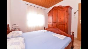 sypialnia z łóżkiem i drewnianą szafką w obiekcie Čeprljanda Ugljan w mieście Ugljan