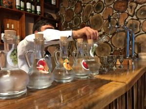 a man standing behind a counter with several glass vases at COMMUNE hotel in Garni +64 photos