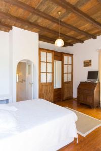 una camera da letto con un letto bianco e un soffitto in legno di Traditional Mykonian Villa a Ornos