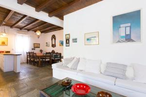 a living room with a white couch and a table at Traditional Mykonian Villa in Ornos