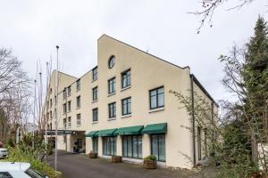 een groot wit gebouw met groene luifels bij Trip Inn Bristol Hotel Mainz in Mainz