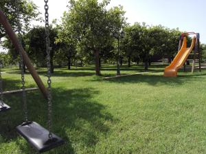 a swing set in a park with a slide at Terra Dei Limoni in Noto Marina
