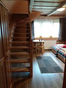 ザコパネにあるZakopane góralski domekのベッドとテーブルが備わる客室内の階段