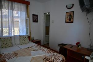 1 dormitorio con 1 cama, ventana y escritorio en Pensiunea Cristina si Pavel en Sighişoara