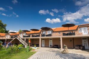 a building with tables and umbrellas in the courtyard at Apartmani "ROSHU" in Soko Banja