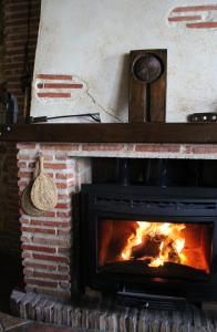 a fireplace with a fire burning in it at Hotel Velad in Vélez Blanco