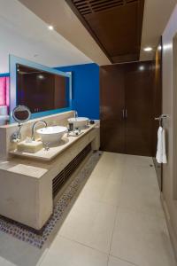 a bathroom with two sinks and a large mirror at Hard Rock Hotel Cancun - All Inclusive in Cancún