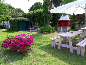 a picnic table and a bench and flowers in a yard at Asteras hotel in Hanioti