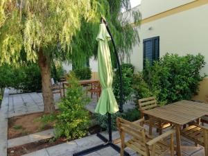 カザラーノにあるSabellの座卓とベンチの横に並ぶ緑の傘