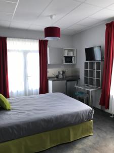 a bedroom with a bed with red curtains and a kitchen at SmartAppart Saint Nazaire in Saint-Nazaire +40 photos