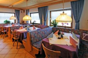a restaurant with several tables with purple tablecloths at Gasthof Walde in Rifiano