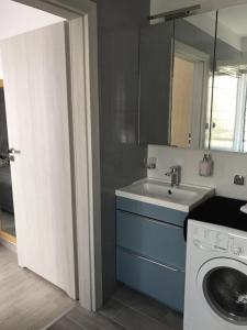 a kitchen with a washing machine and a sink at Secret Garden by Arder in Gdynia +29 photos