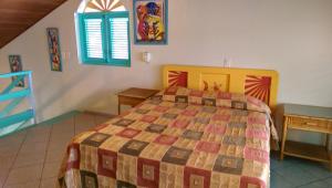 ein Schlafzimmer mit einem Bett mit einer Decke darauf in der Unterkunft Las Palmas Eco Residence in Las Terrenas