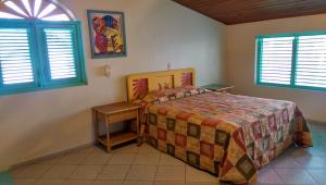 a bedroom with a bed and two windows at Las Palmas Eco Residence in Las Terrenas