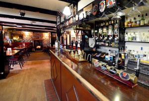 a bar in a restaurant with a lot of alcohol at The Farmers Inn in Dumfries