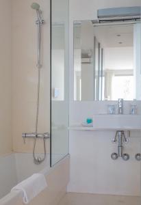 W łazience znajduje się prysznic, umywalka i lustro. w obiekcie Hotel Las Palmas w mieście Carboneras
