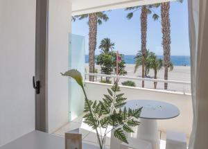 a room with a view of the beach and palm trees at Hotel Las Palmas in Carboneras