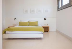 a white bedroom with a bed and a window at Hotel Las Palmas in Carboneras
