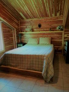 a bedroom with a bed in a wooden cabin at Cedar cabin located on a buffalo farm in Marshall