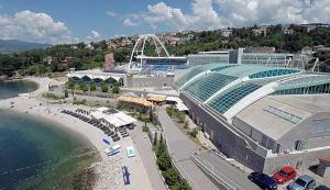 a large building next to a beach with a stadium at Flumine in Rijeka