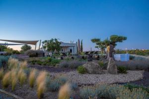 a garden with a statue of a woman and a tree at Espargosa Monte de Baixo & Art in Castro Marim