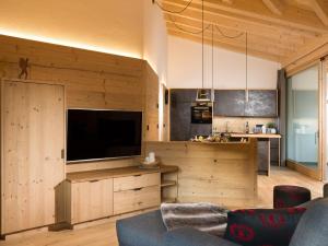 ein Wohnzimmer mit einem großen Flachbild-TV in der Unterkunft Chalet Novalis in Innichen