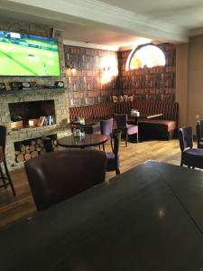 a bar with a fireplace and a tv in a room at The Brandywell in Dromod