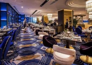un ristorante con tavoli e sedie e persone sullo sfondo di Euphoria Hotel Batumi a Batumi
