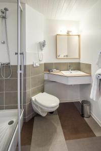 a bathroom with a toilet and a sink and a shower at Carré Pau Airport Hôtel in Serres-Castet