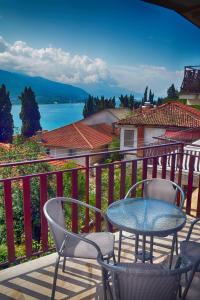 a table and chairs on a balcony with a view of the water at Comfort Apartment in Ohrid
