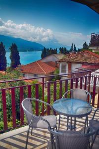 einen Tisch und Stühle auf einem Balkon mit Blick auf das Wasser in der Unterkunft Comfort Apartment in Ohrid