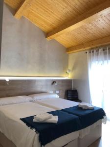 a bedroom with a bed with two towels on it at Casita del Abuelo Mayorga in Plasencia