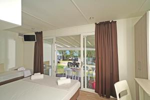 a bedroom with two beds and a view of a patio at Camping Spiaggia D' Oro Torri in Torri del Benaco