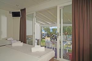 a room with two beds and a view of a patio at Camping Spiaggia D' Oro Torri in Torri del Benaco
