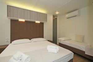 1 dormitorio con 2 camas y toallas. en Camping Spiaggia D' Oro Torri, en Torri del Benaco