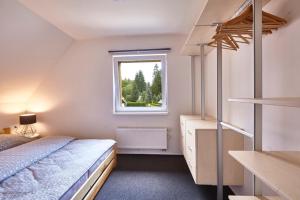 Schlafzimmer mit einem Bett und einem Fenster in der Unterkunft Chata Maruška in Harrachov