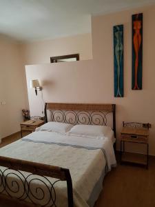 a bedroom with a bed and two paintings on the wall at Bed and Breakfast da Gigi e Antonella in Porto Rotondo
