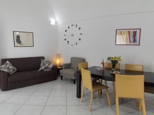a living room with a couch and a table and chairs at Barnab@House in Monopoli