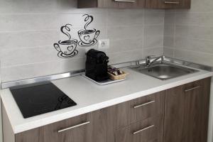 a kitchen counter with a sink and two cups on the wall at Barnab@House in Monopoli +17 photos
