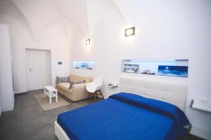 a bedroom with a blue bed and a couch at IL VIAGGIATORE VIA INDIPENDENZA 2 in Gaeta