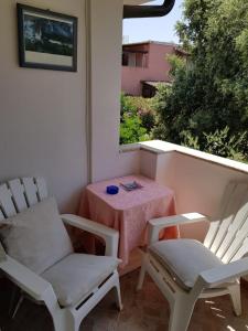 a patio with two chairs and a table and a window at Bed and Breakfast da Gigi e Antonella in Porto Rotondo