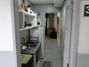 a small kitchen with a sink and a refrigerator at Edificio Edmeia in Praia Grande