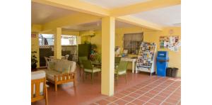 a living room with yellow walls and a table and chairs at Meridian Inn in Christ Church