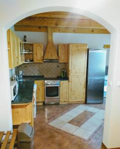 a kitchen with wooden cabinets and a stainless steel refrigerator at Apartman pod Kalváriou - rodinný dom in Banská Štiavnica