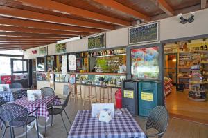 un ristorante con tavoli e sedie e un bar di Camping Spiaggia D' Oro Torri a Torri del Benaco