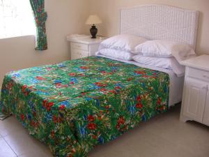 a bed with a colorful quilt on it in a bedroom at Plover Court Apartments in Christ Church